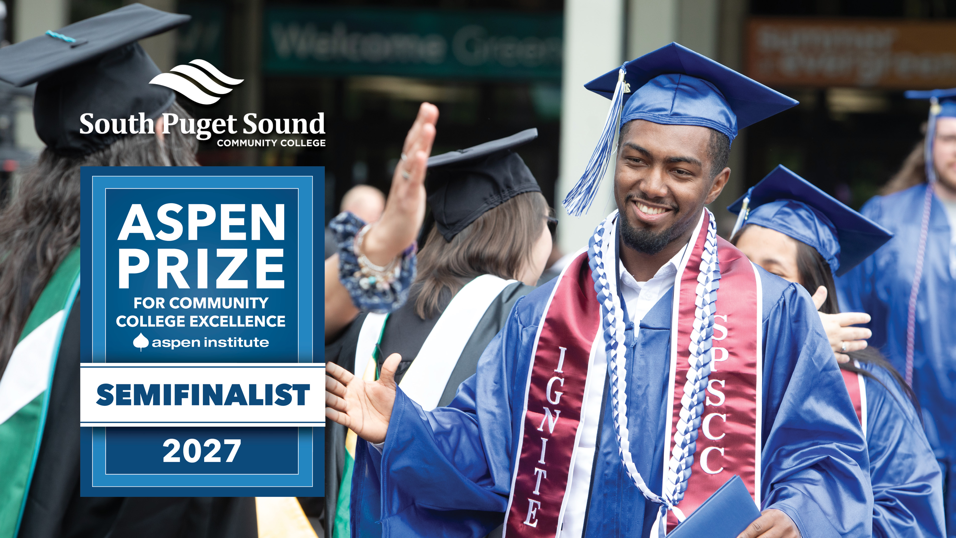 An SPSCC graduate shaking hands with a SPSCC professor with a badge that reads "Aspen Prize for Community College Excellence Semifinalist"