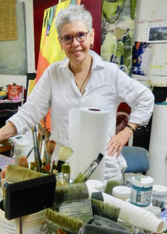 Portrait of artist Becky Knold behind art supplies
