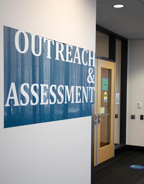 Interior building wall and doors with blue graphic stating "outreach & assessment"