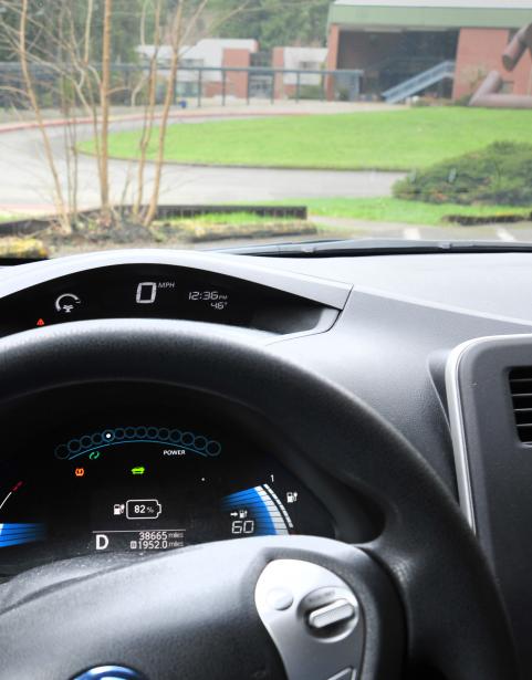 The dashboard and steering wheel of an electric vehicle looking out onto the SPSCC campus