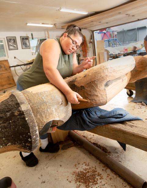 Artist Andrea Wilbur-Sigo (Squaxin Island and Skokomish) carving the SPSCC Welcome Figure in her workshop