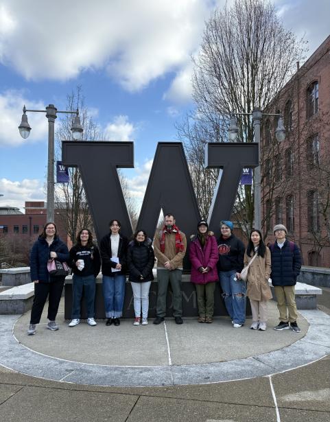 A group of SPSCC students in front of University of Washington Tacoma's W logo statue