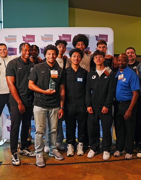 Members of the Clipper Men’s Basketball Team and SPSCC Athletic Director (in blue) pose with the Olympia & Beyond Sports Award for Best Sports Moment. 