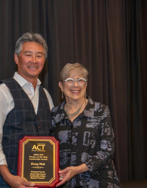 SPSCC Trustee Doug Mah (left) receives the Washington State ACT Trustee Leadership Award from Seattle Colleges Trustee Louise Chernan.