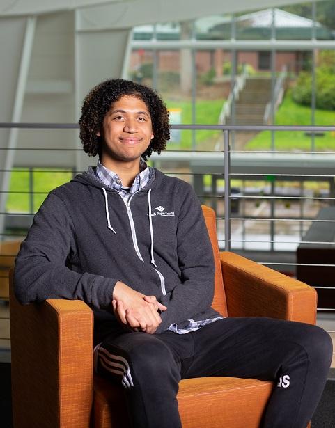 Smiling student sits in orange soft chair
