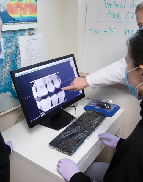photo of students looking at a computer with final radiograph displayed