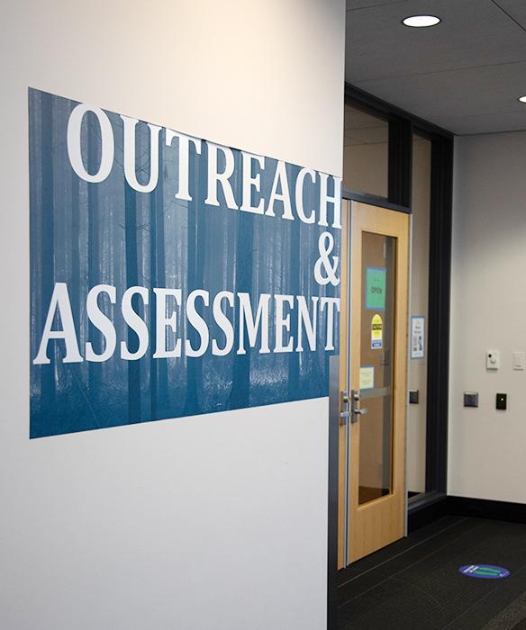 Interior building wall and doors with blue graphic stating "outreach & assessment"