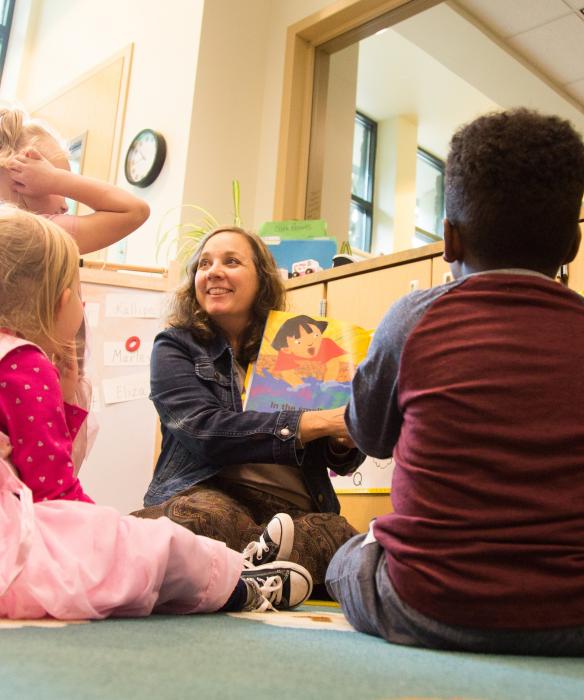 Teacher reads a picture book to a group of young children