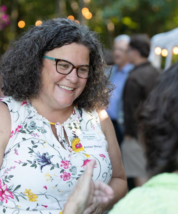 Woman in glasses smiles in conversation