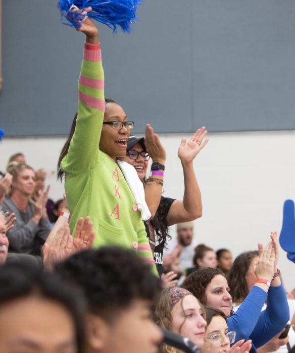 A crowd of people cheering in a gym