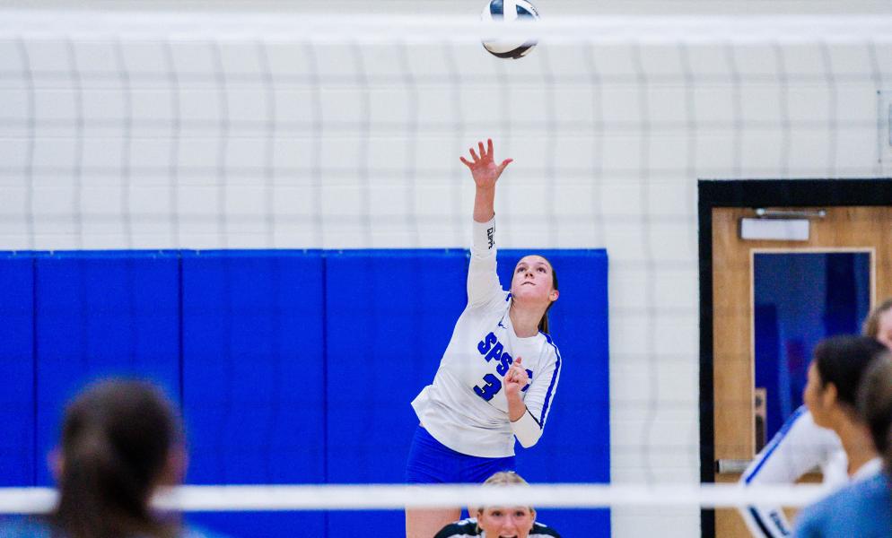 Photo of student-athlete Emily Snider serving a volleyball