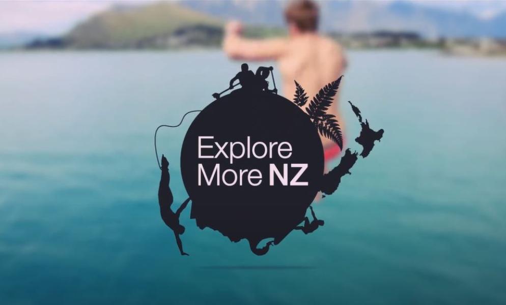 the Explore More NZ logo is displayed over a person jumping into water 