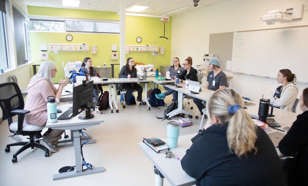 Nursing students sitting at tables in the Angela J. Bowen Center for Health Education