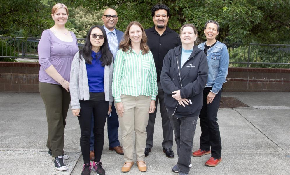 Twelve faculty members standing outside