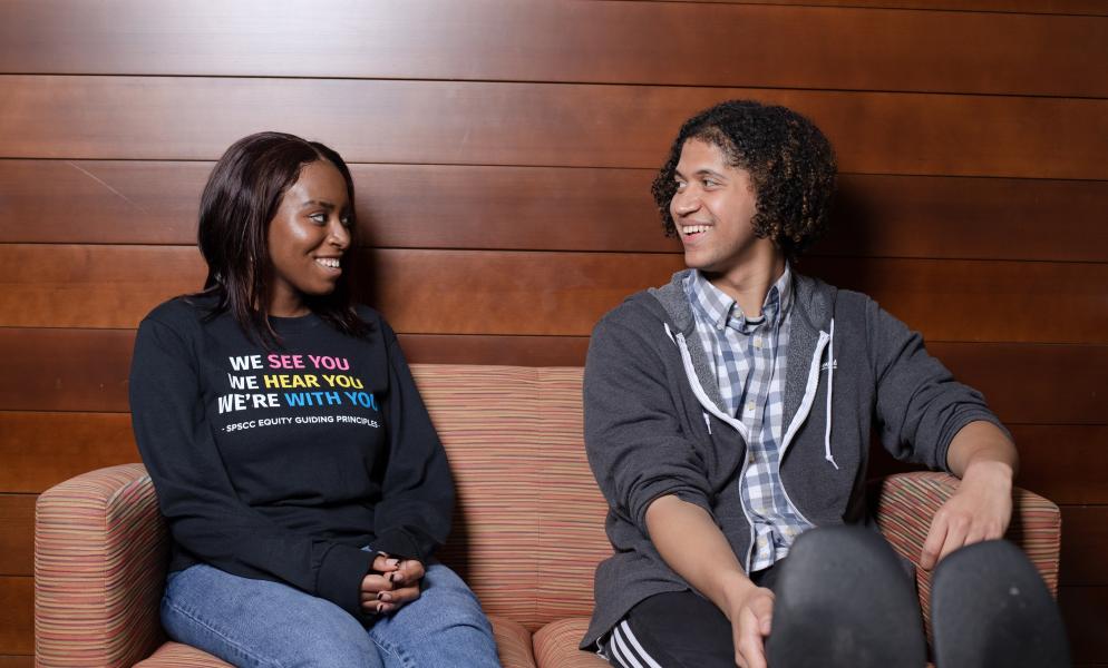 Students talk and smile on a couch