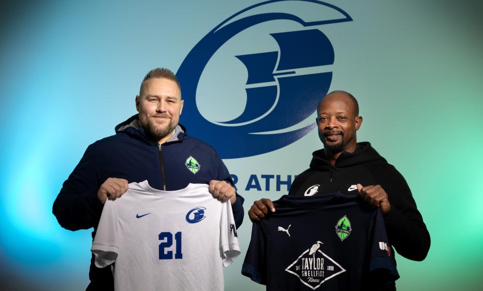 FC Olympia owner Ryan Perkins holding a Clipper jersey alongside SPSCC Director of Athletics Vernell Willingham holding an FC Olympia jersey